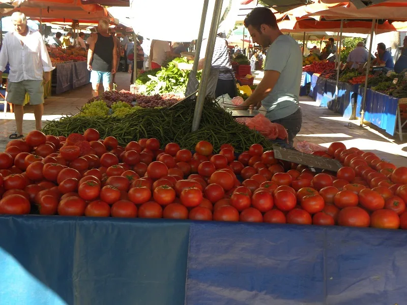 Ντομάτες και πωλητής σε πάγκο Λαϊκής αγοράς εικόνα